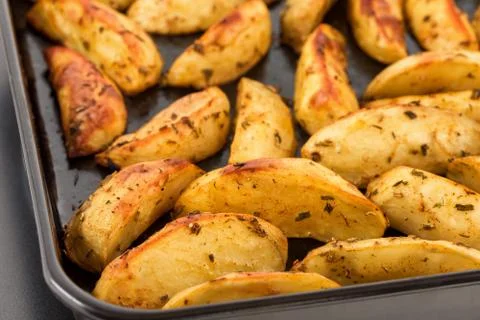 Baked potatoes on baking sheet Stock Photos