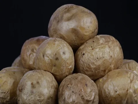 Baked potatoes on a black background rotates, close up Stock Footage 77765138