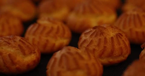 Baked profiteroles, close-up of eclair caps, sweet desserts for a large family. Stock Footage 252188882