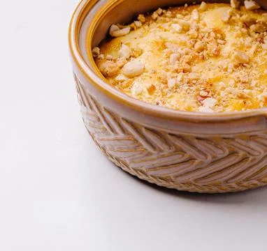 Baked pudding dessert with nuts in ceramic bowl Stock Photos
