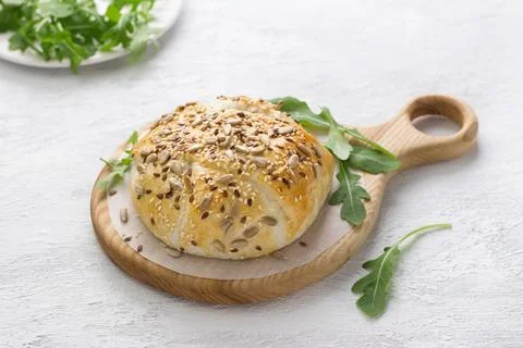 Baked in puff pastry cheese sprinkled with seeds decorated with fresh arugu.. Stock Photos