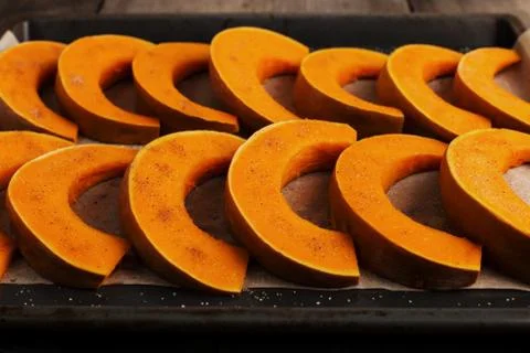 Baked pumpkin on a baking sheet, ready to bake. Stock Photos