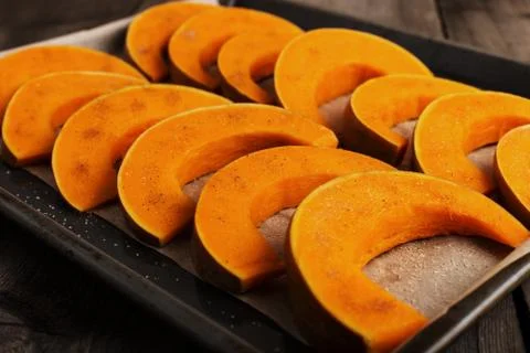 Baked pumpkin on a baking sheet, ready to bake. Stock Photos
