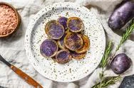 Baked Purple Potatoes With Pink Salt. Gray Background. Top View Stock Photos