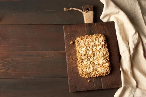 Baked rectangular crumble cake with fruit filling on wooden board, brown back Stock Photos