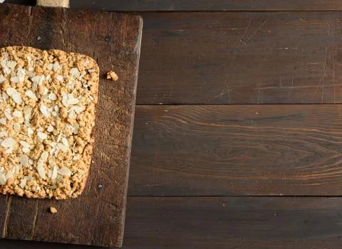 Baked rectangular crumble cake with fruit filling on wooden board Stockfoto's