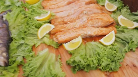 Baked red salmon with salad. Cooked fish fillets with greens and lemon on the Stock Footage 83080451