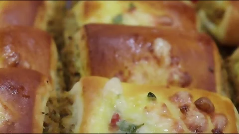 Baked rolls close up with melted cheese and colorful vegetables arranged Stock Footage 338163930