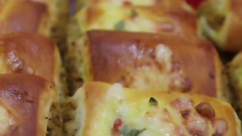 Baked rolls close up with melted cheese and colorful vegetables arranged Stock Footage 338164060
