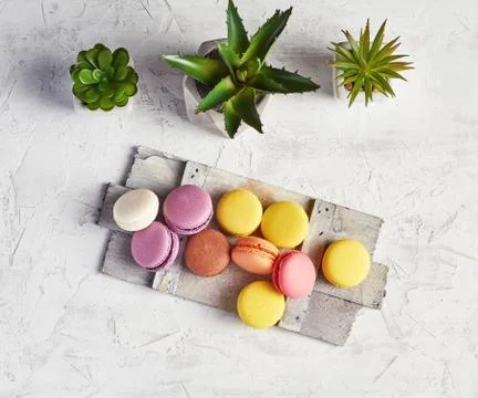 Baked round multi-colored macarons on a wooden board Foto stock