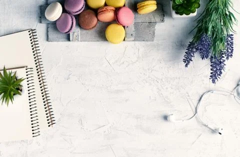 Baked round multi-colored macarons on a wooden board, stack of spiral noteboo Stockfoto's