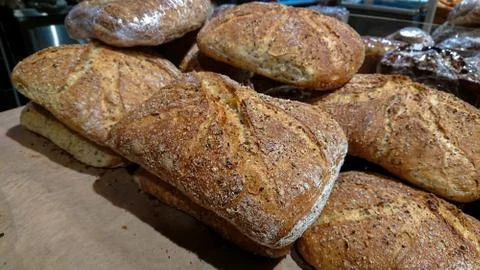Baked rustic organic loaf bread on the counter in the bakery. Stock Photos