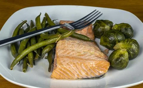 Baked salmon with string  beans and brussel sprouts Stock-Fotos