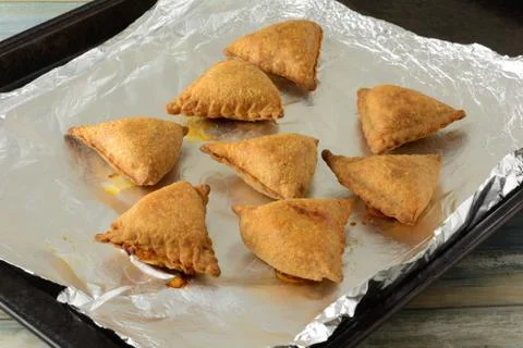 Baked samosa snacks on baking sheet Stock Photos