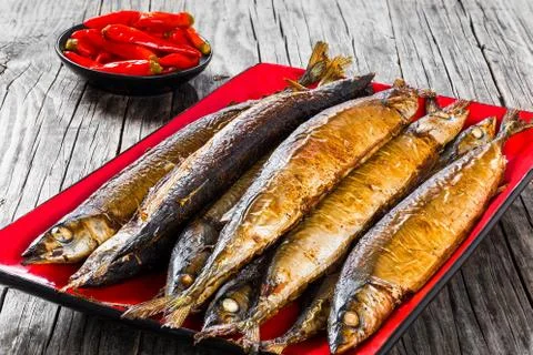 Baked saury on a red rectangular dish , close-up top view Stock Photos