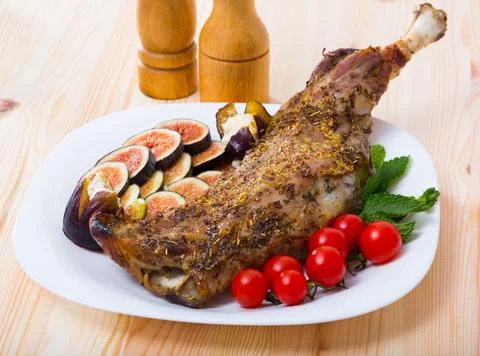Baked shoulder of mutton with figs, tomatoes, soft cheese Stock Photos