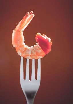 Baked shrimpon a fork, on brown background Stock Photos