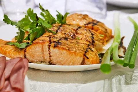 Baked solomon with herbs on a plate on a served table Stock Photos