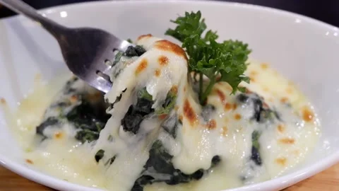 Baked Spinach with Cheese is scooped by a fork in a white plate. Stock Footage 134256361
