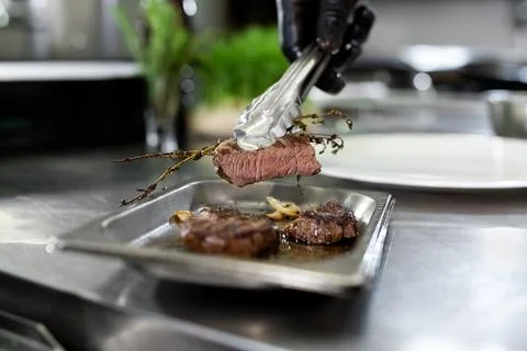 Baked steak with herbs on a baking sheet. Stock Photos