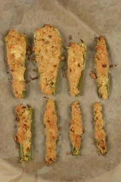 Baked stuffed celery stalks on baking paper top view Stock Photos
