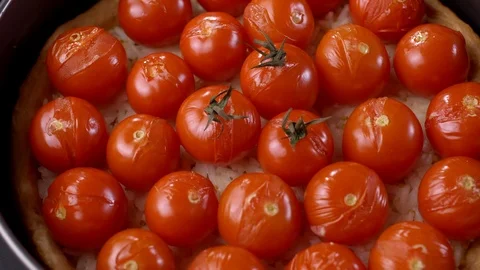 Baked tart with cherry tomatoes close-up view.Cooking dinner in slow motion. 動画素材 122169246
