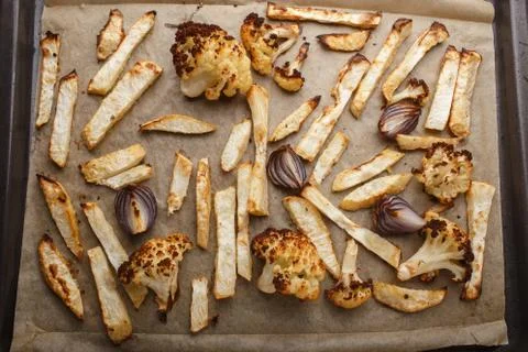 Baked vegetables on a baking sheet - celery, cauliflower and red onion Foto stock