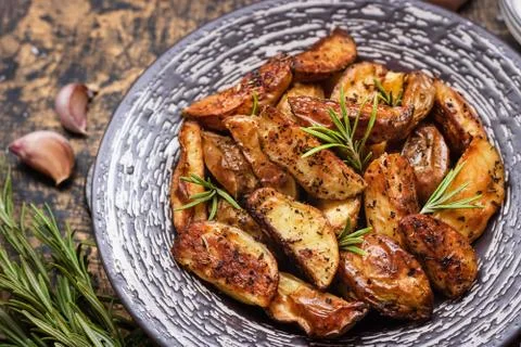 Baked young potatoes in a rustic style with sour cream Stock Photos