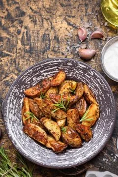 Baked young potatoes in a rustic style with sour cream Stock Photos