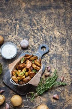 Baked young potatoes in a rustic style with sour cream Stock Photos