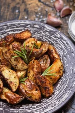 Baked young potatoes in a rustic style with sour cream Stock Photos