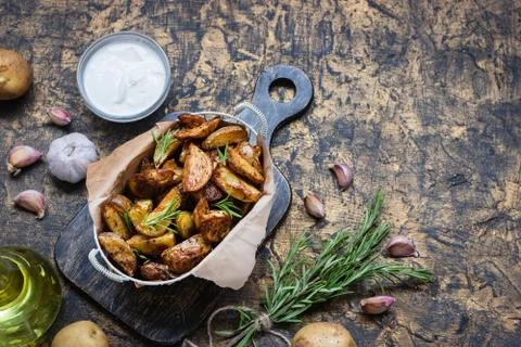 Baked young potatoes in a rustic style with sour cream Stock Photos