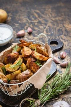 Baked young potatoes in a rustic style with sour cream Stock Photos