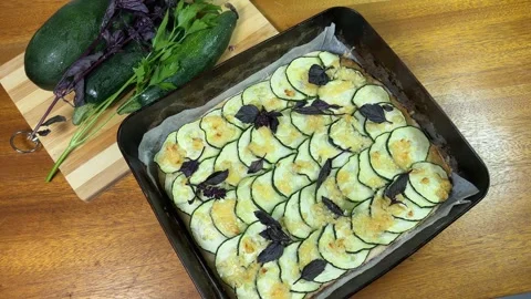 Baked zucchini pizza in deep baking sheet and raw zucchini Stock Footage 320257509