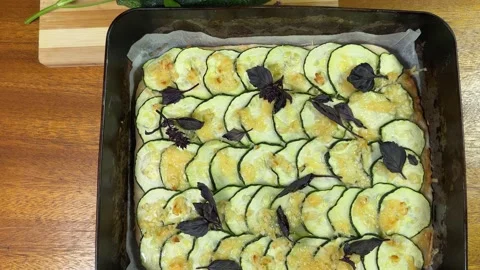 Baked zucchini pizza in deep baking sheet and raw zucchini Stock Footage 320258006