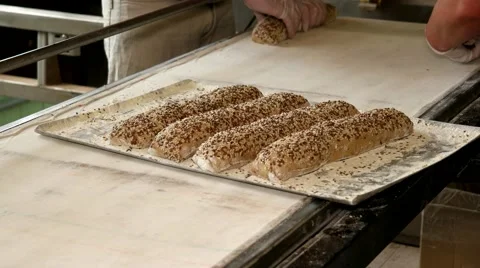 Bakehouse. Process of preparing baguettes with seeds to place in the oven Stock-Footage 64470982