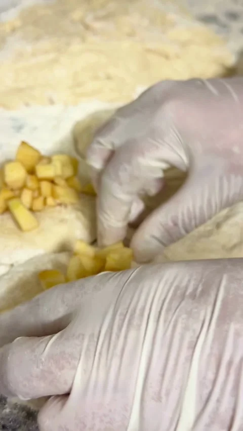 Baker adding chopped apples to raw dough for pastries Video stock 331981768