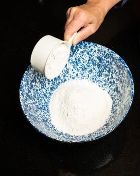 Baker adding ingredients to bowl Stock Photos