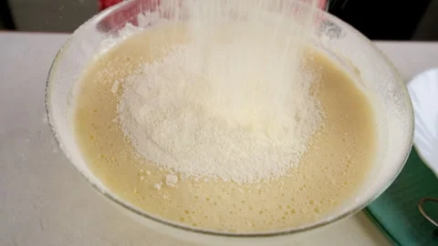 Baker adding mixing flour into batter with electric mixer cooking biscuit dough. Stock Footage 311528719