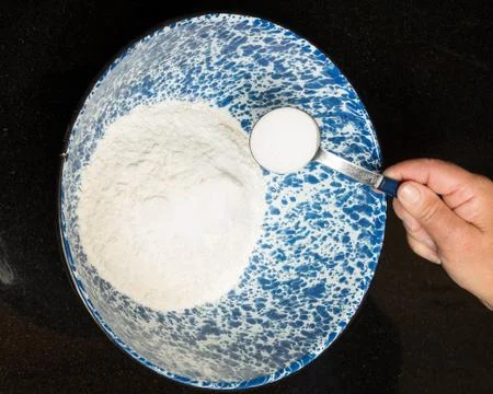 Baker adding salt to bread mix Stock Photos
