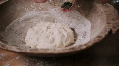 Baker adding starter to dough Stock Footage 130380677
