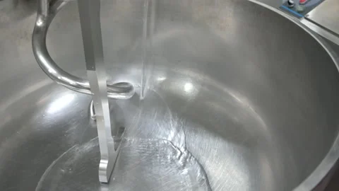 Baker Adding Water to a Professional Kneading Machine Stock Footage 195363323