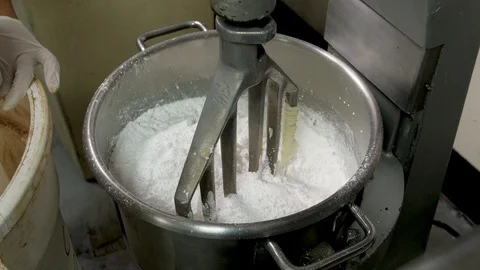 Baker adds cocoa to white sugar in large mixer Stock Footage 94241902