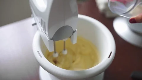 Baker adds milk to the mixer cup, making the dough, housewife cooks in the Stock Footage 71296079