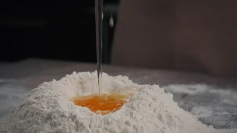 The baker adds a raw egg to the dough. Slow motion Stock Footage 201547239