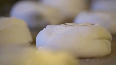 Baker applying egg wash over the rolled dough with a brush Stock Footage 87613019