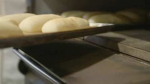 Baker baking bread loafs in an industrial oven Stock Footage 87612206