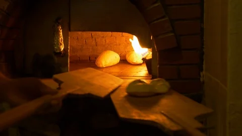 Baker baking fresh bead on oven in italian bakery shop. Close up man baker Stock Footage 119945847