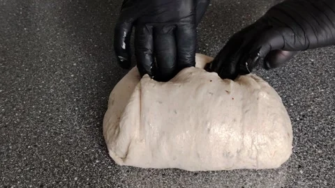 Baker with black gloves kneading and folding sourdough bread dough. Stock Footage 333756796
