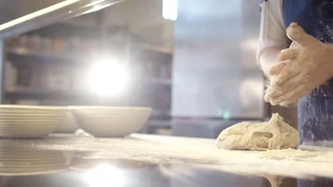 Baker in Blue Apron Kneading Dough, Bright Artisan Bakery, Medium Shot Stock Footage 341340102